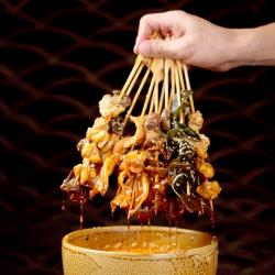 制作美味冷串串：各种配菜煮熟，串入竹签，浇上特制酱汁
